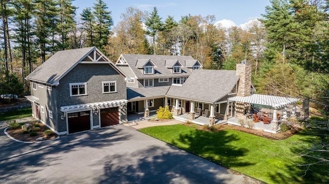 view of front of home with a garage, a front lawn, and covered porch