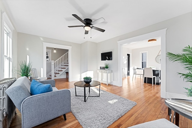 living room with ceiling fan and light hardwood / wood-style flooring