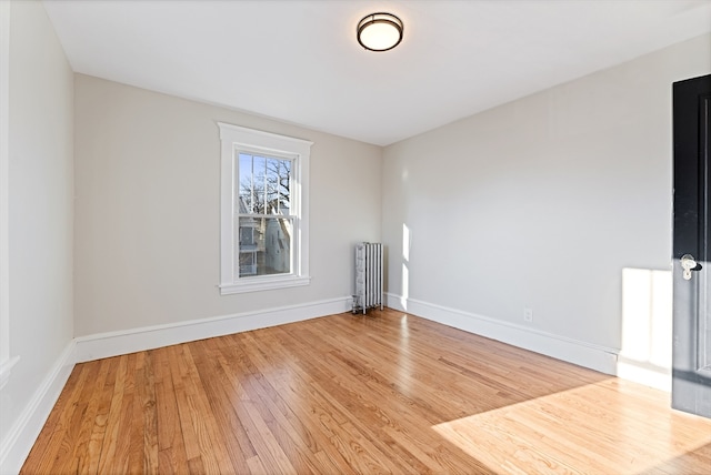 empty room with radiator and light hardwood / wood-style flooring