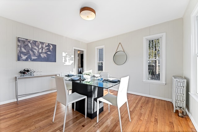 dining area with radiator and light hardwood / wood-style floors