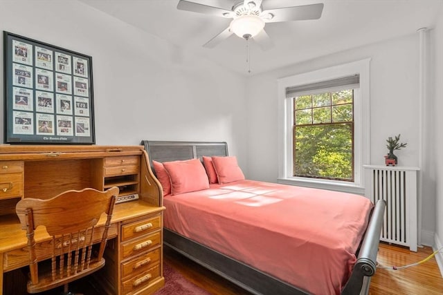 bedroom with ceiling fan, dark hardwood / wood-style floors, and radiator