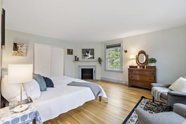 14 Thoreau St, Concord, MA 01742 - bedroom with light wood finished floors, a closet, and a fireplace