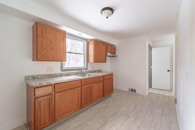 kitchen with sink and light hardwood / wood-style flooring