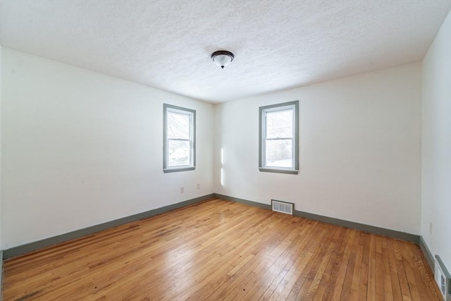 empty room featuring light hardwood / wood-style flooring and a textured ceiling