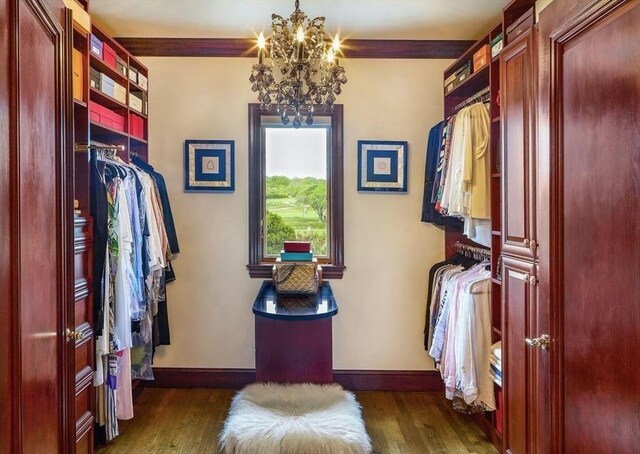 bedroom with a water view, ornamental molding, hardwood / wood-style flooring, and a notable chandelier