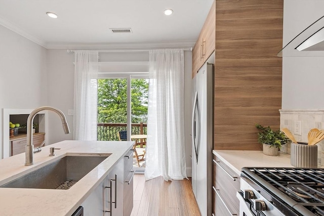 24 Lemon St Unit 2, Salem, MA 01970 - kitchen with freestanding refrigerator, recessed lighting, light stone countertops, decorative backsplash, and ornamental molding