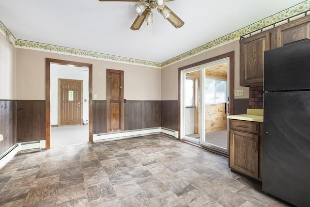 10 Hazel Plz, Uxbridge, MA 01569 - unfurnished dining area featuring a wainscoted wall, wood walls, a baseboard radiator, a ceiling fan, and baseboard heating