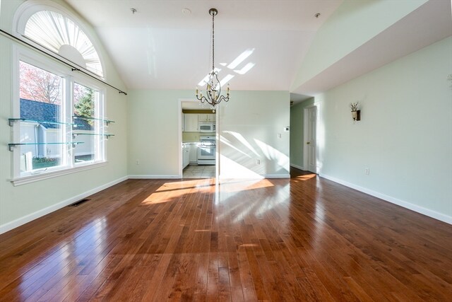 unfurnished dining area featuring a chandelier, dark wood-style flooring, visible vents, and baseboards