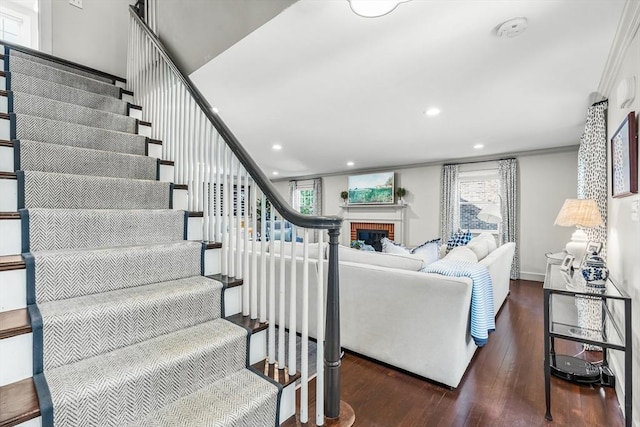 stairs with wood-type flooring, plenty of natural light, a fireplace, recessed lighting, and ornamental molding