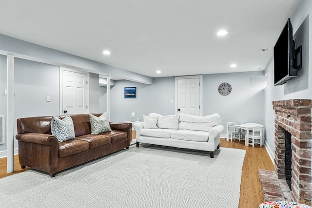 living room with wood finished floors, recessed lighting, a fireplace, and baseboards