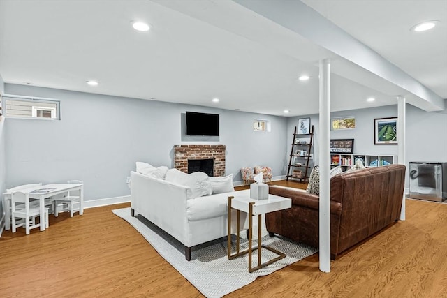 living area with light wood-type flooring, recessed lighting, a fireplace, and baseboards