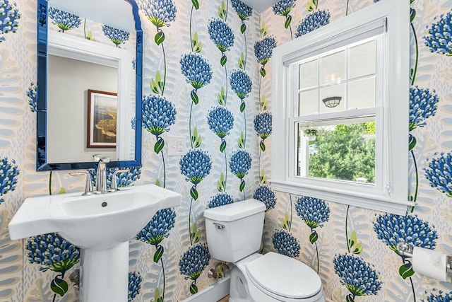 half bath with toilet and wallpapered walls