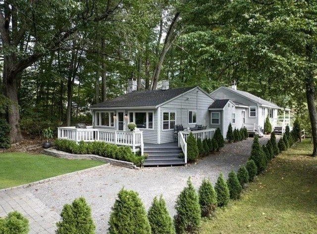 view of front facade featuring a front yard and a deck