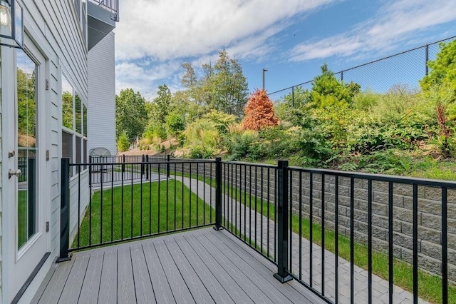 wooden deck featuring a lawn