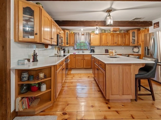 58 Fitzpatrick Rd, Grafton, MA 01519 - kitchen with stainless steel appliances, a kitchen island, glass insert cabinets, light wood-style flooring, and light countertops