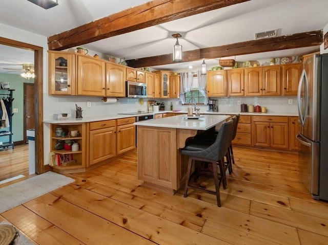 58 Fitzpatrick Rd, Grafton, MA 01519 - kitchen featuring appliances with stainless steel finishes, light wood-style floors, backsplash, glass insert cabinets, and beam ceiling