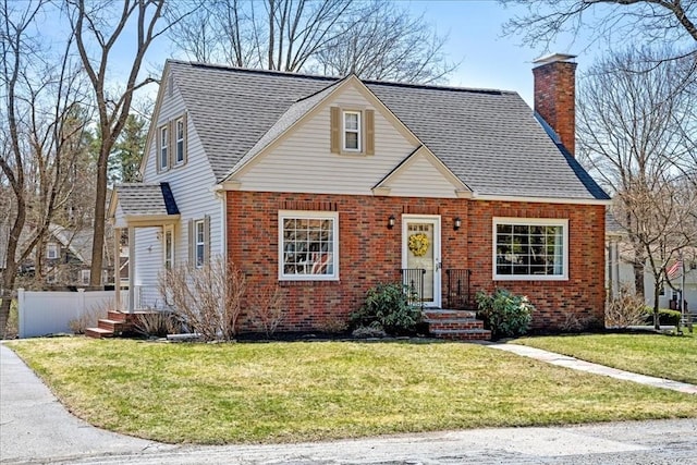 view of front facade featuring a front lawn, a chimney, fence, brick siding, and a shingled roof