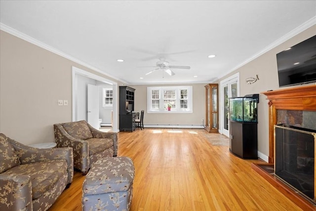 living area featuring a tiled fireplace, recessed lighting, light wood-style floors, a ceiling fan, and a baseboard radiator