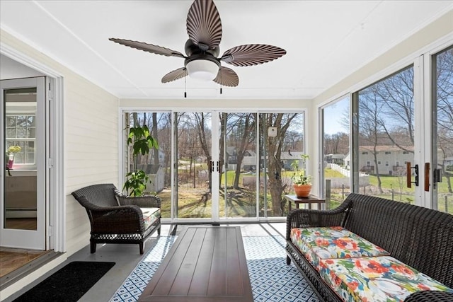 sunroom with a baseboard radiator, ceiling fan, and plenty of natural light
