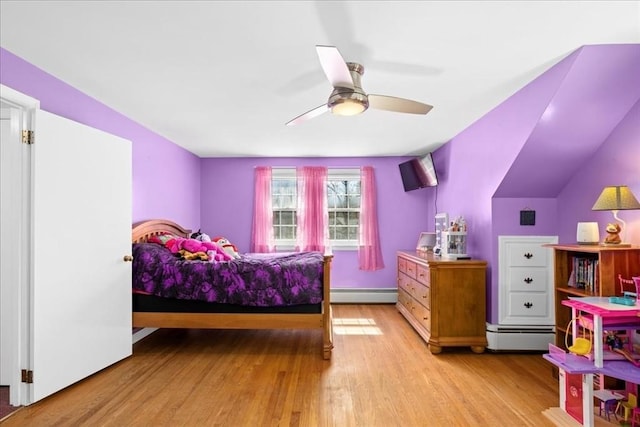 bedroom with a baseboard heating unit, ceiling fan, and light wood-style flooring