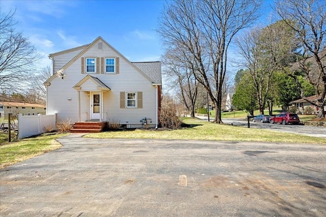 view of front of house with a front lawn, fence, and aphalt driveway