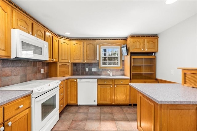 kitchen featuring recessed lighting, a sink, white appliances, decorative backsplash, and brown cabinetry
