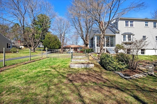 view of yard featuring fence and a vegetable garden