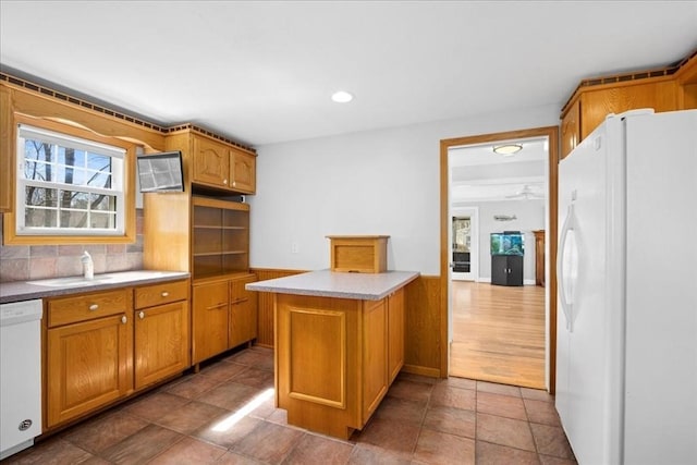 kitchen with brown cabinets, a peninsula, and white appliances