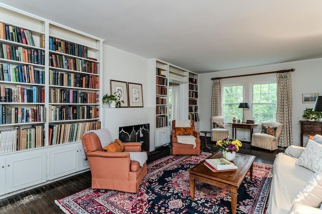sitting room with dark wood-type flooring and ornamental molding