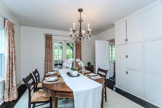 dining room with a chandelier, wood finished floors, and crown molding