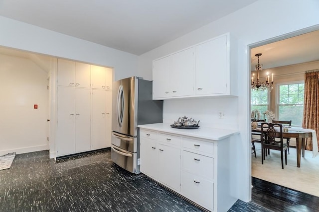 kitchen with freestanding refrigerator, a chandelier, light countertops, and white cabinets