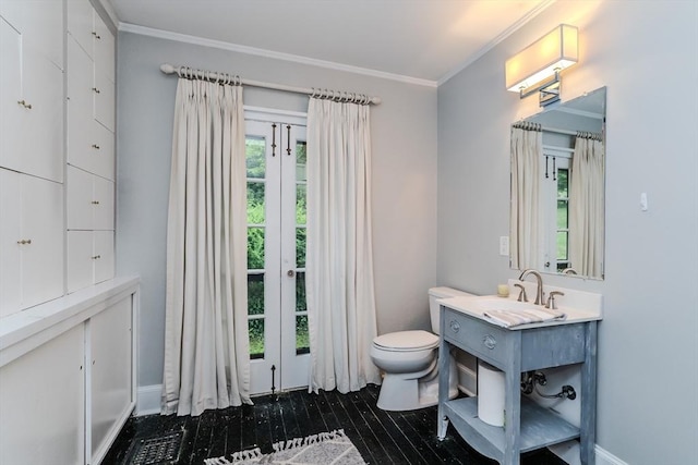 bathroom featuring toilet, crown molding, and vanity