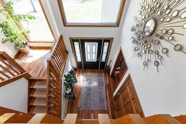 entrance foyer with wood finished floors, a high ceiling, and stairway