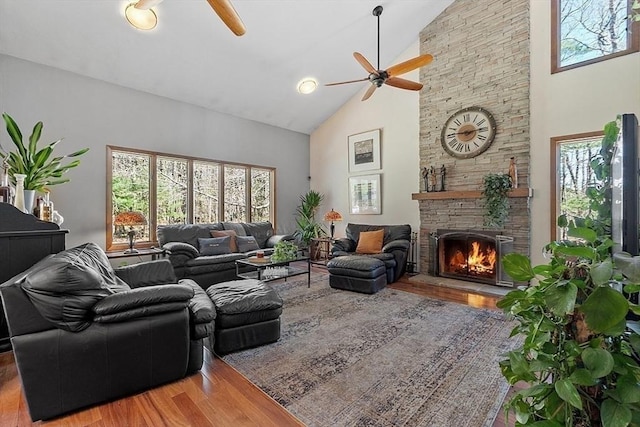 living room with wood finished floors, a ceiling fan, and a healthy amount of sunlight