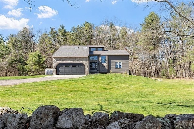 view of front of home featuring an attached garage, driveway, and a front lawn