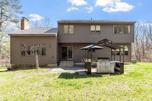 back of property with a patio, a chimney, a lawn, entry steps, and a shingled roof