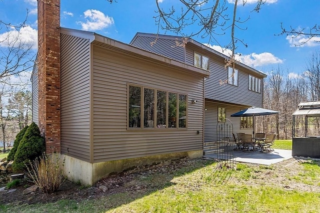 back of property with a patio and a chimney