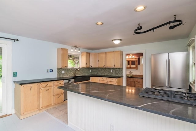 28 River St, Erving, MA 01344 - kitchen with appliances with stainless steel finishes, a sink, dark countertops, light brown cabinets, and tasteful backsplash