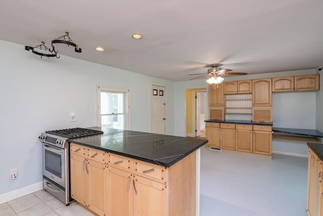 28 River St, Erving, MA 01344 - kitchen featuring stainless steel range with gas stovetop, light brown cabinets, a peninsula, ceiling fan, and dark countertops