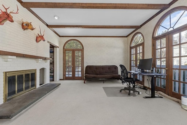 carpeted office space featuring a brick fireplace, ornamental molding, beam ceiling, and french doors