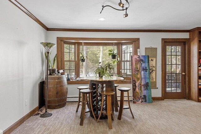 carpeted dining room featuring ornamental molding, a baseboard radiator, and baseboards