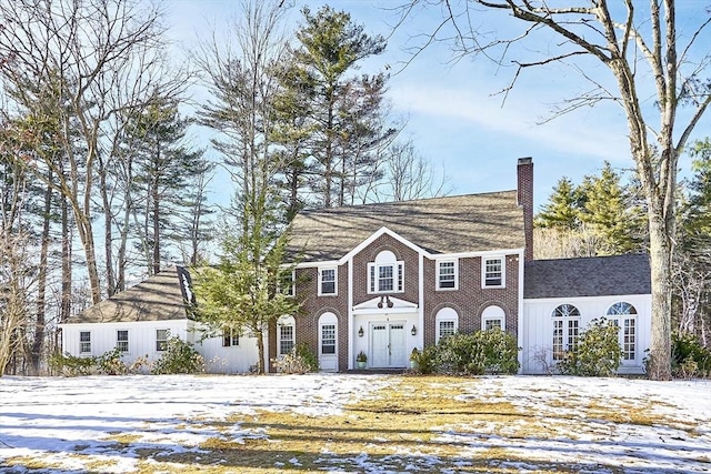 view of front of property featuring brick siding and a chimney