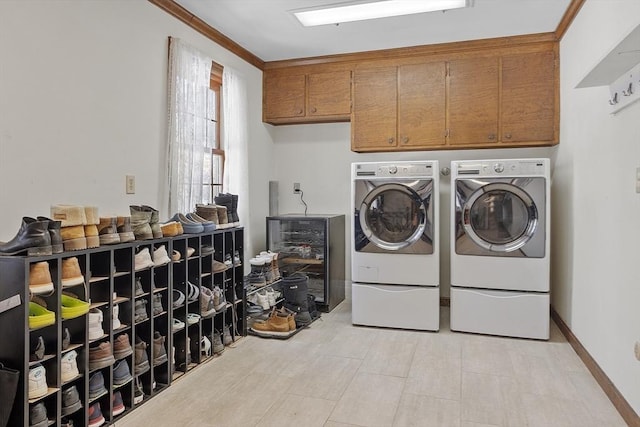 washroom with cabinet space, wine cooler, baseboards, and independent washer and dryer