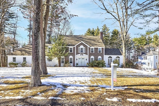 view of front of property with a chimney and brick siding