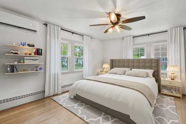 20 Marjorie Rd, Wilmington, MA 01887 - bedroom with a wall unit AC, multiple windows, wood finished floors, and ceiling fan
