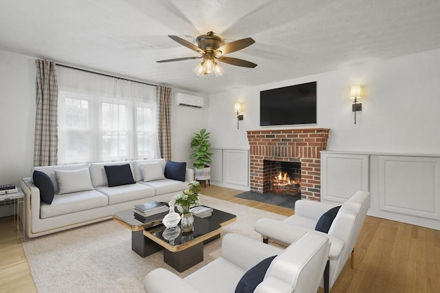 20 Marjorie Rd, Wilmington, MA 01887 - living area with an AC wall unit, light wood-style flooring, a brick fireplace, and a ceiling fan