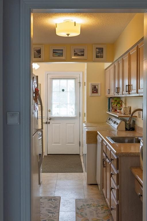 61 Outer Dr Unit 61, Chicopee, MA 01022 - kitchen with a sink, light tile patterned floors, light countertops, brown cabinetry, and stove