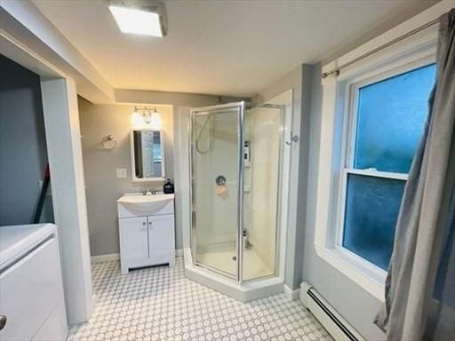 bathroom with baseboard heating, vanity, tile patterned floors, baseboards, and a stall shower