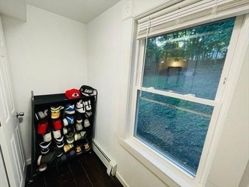 doorway to outside featuring a baseboard heating unit and wood finished floors