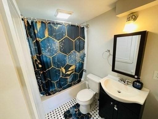 bathroom featuring vanity, tile patterned floors, shower / bath combo with shower curtain, and toilet